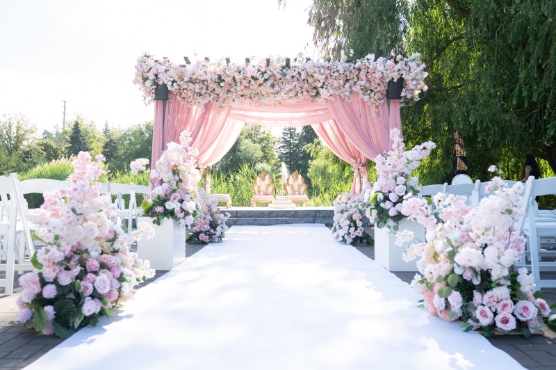 White aisle leading to a blush draped floral canopy outdoors by GPS Decors