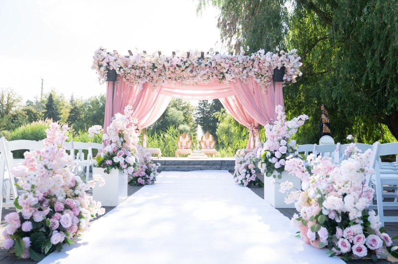 Ceremony canopy with blush draping, pink and lavender florals and a white aisle by GPS Decors