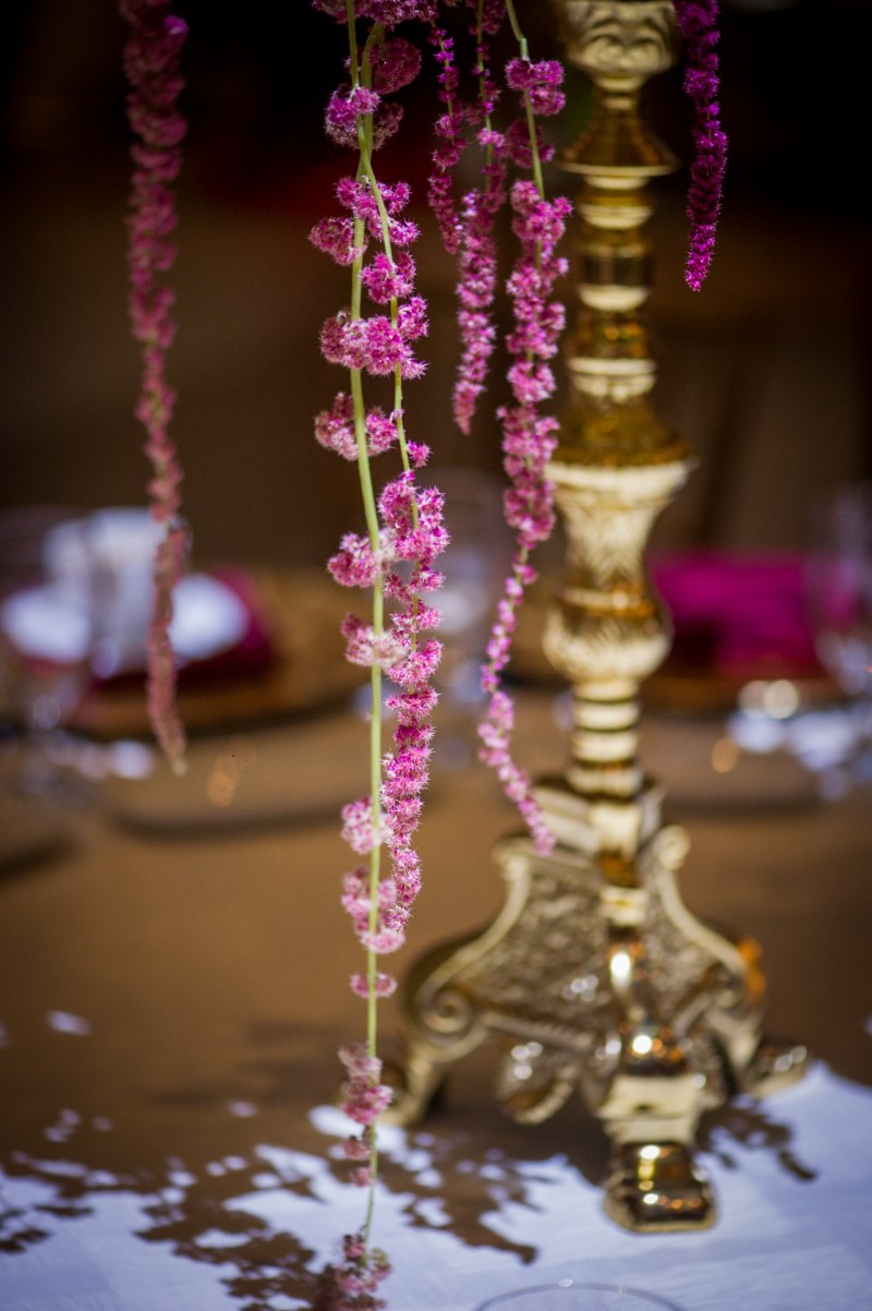 Gold candelabra with trailing pink amaranthus on a mehndi table by GPS Decors