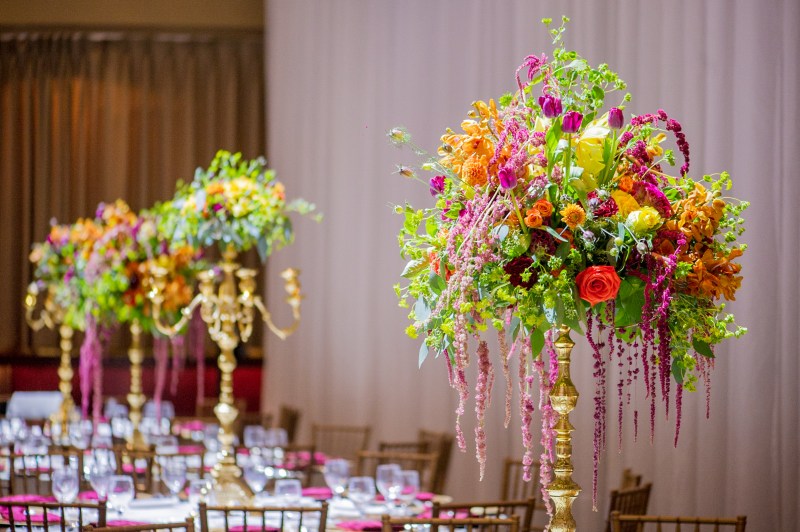 Tall colourful floral centrepiece with hanging amaranthus at a mehndi by GPS Decors