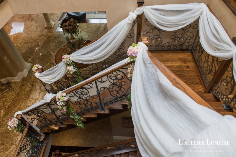Ivory draping and florals along a grand staircase by GPS Decors