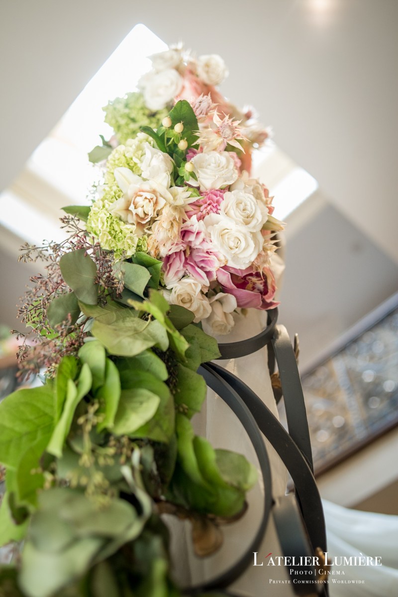 Blush and white florals with greenery on a staircase railing by GPS Decors