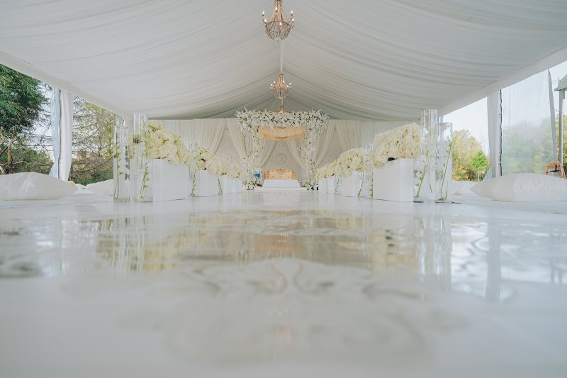 Draped white tent reception with a crystal chandelier by GPS Decors