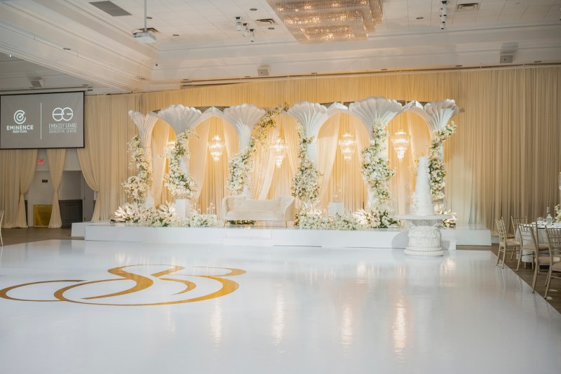 White and gold reception with floral arches and glossy dance floor by GPS Decors