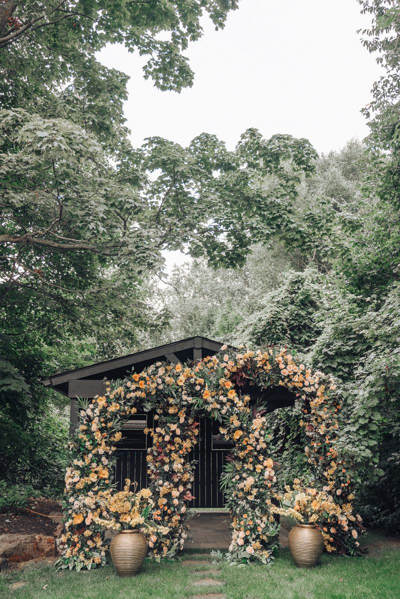 Garden backdrop covered in florals beneath the trees by GPS Decors