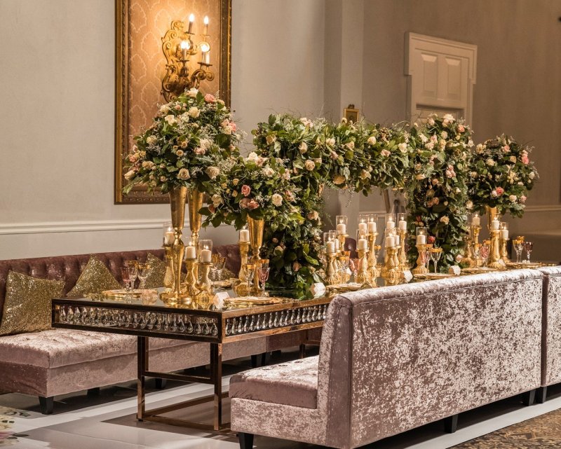 Lounge seating with lush greenery and gold accents by GPS Decors