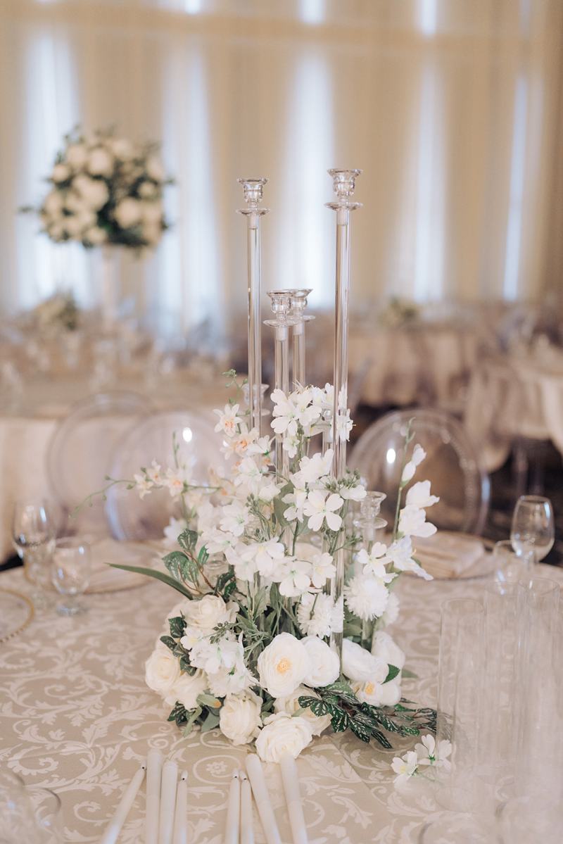 Reception ballroom with ivory draping and white floral centrepieces by GPS Decors