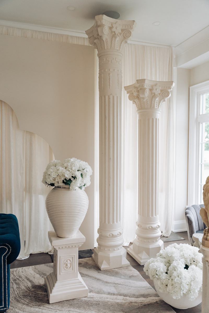 White columns with white floral urns for a wedding ceremony by GPS Decors