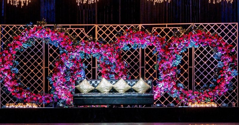 Event lounge with a fuchsia floral wall and lattice backdrop by GPS Decors