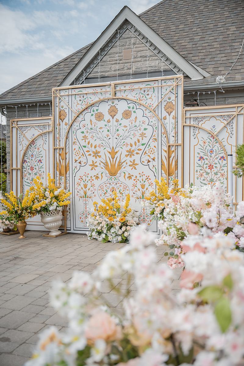 Carved white and gold maiyan backdrop with yellow florals by GPS Decors