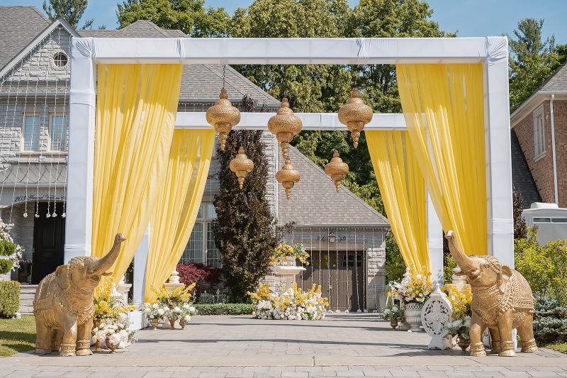 Outdoor maiyan canopy with yellow draping and brass lanterns by GPS Decors