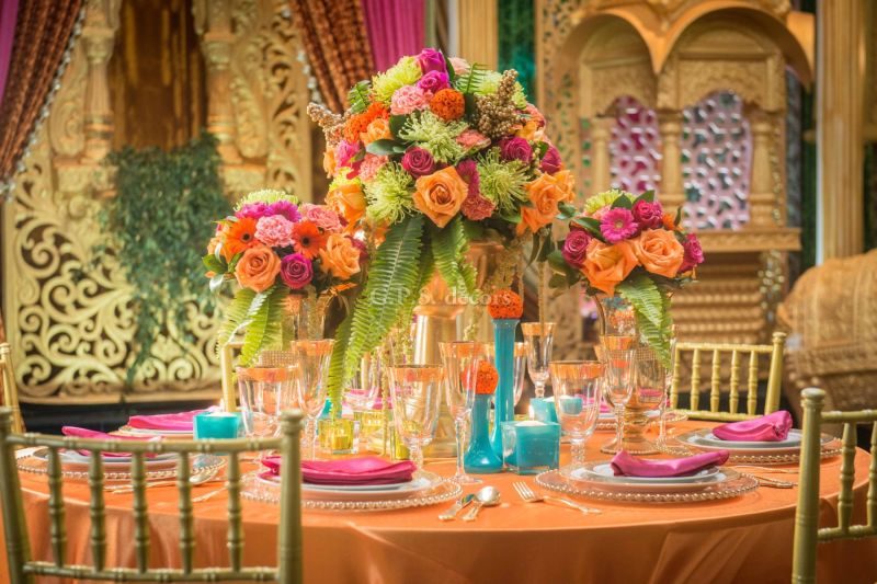Vibrant orange and pink floral centrepiece with turquoise accents by GPS Decors