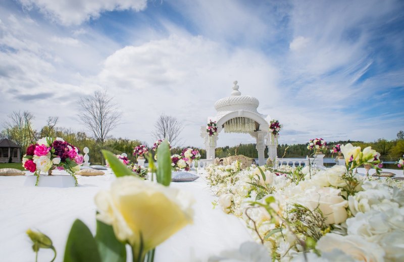 Outdoor garden ceremony with a white gazebo and florals by GPS Decors