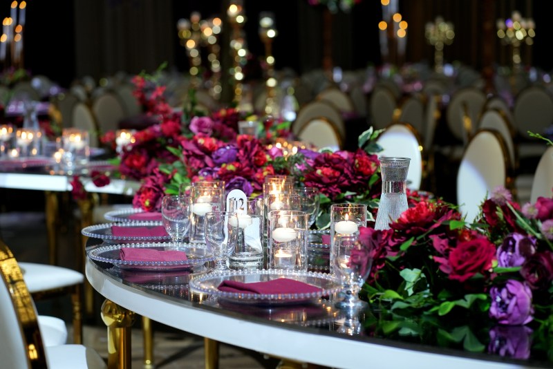 Candlelit table detail with deep red florals by GPS Decors