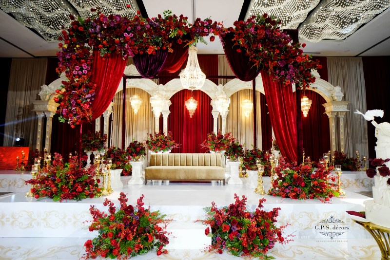 Red and gold reception stage with red roses by GPS Decors