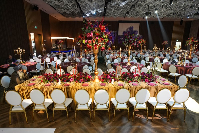 Reception tables with gold linens and tall red floral centrepieces by GPS Decors