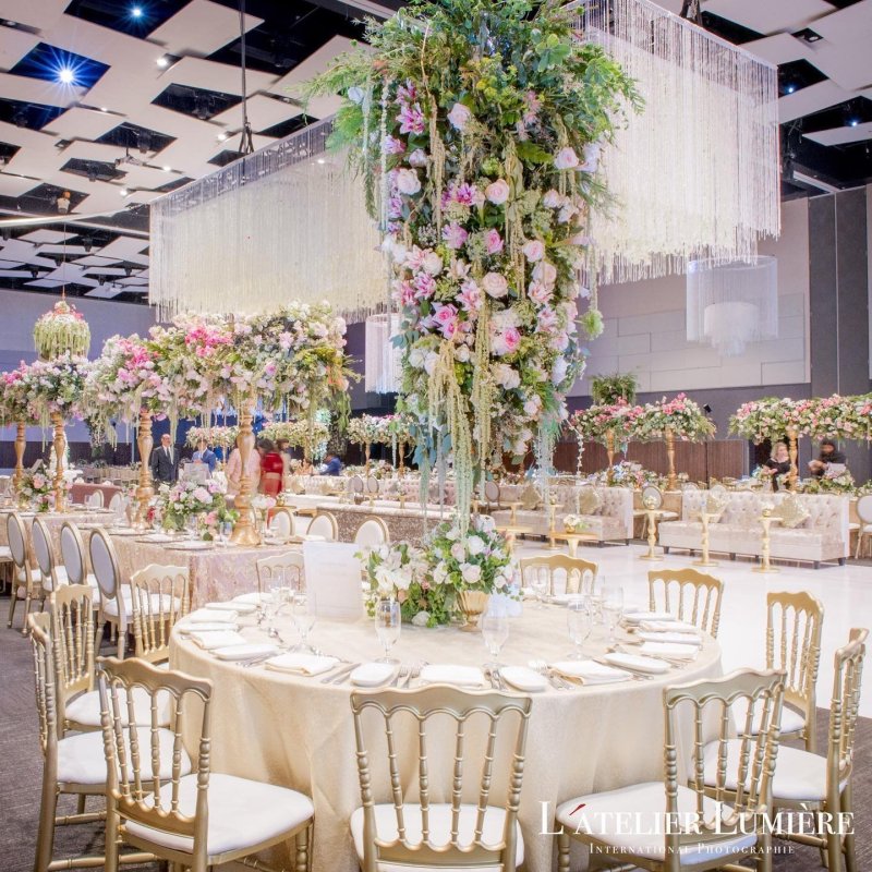 Reception tables with tall floral centrepieces and gold chairs by GPS Decors