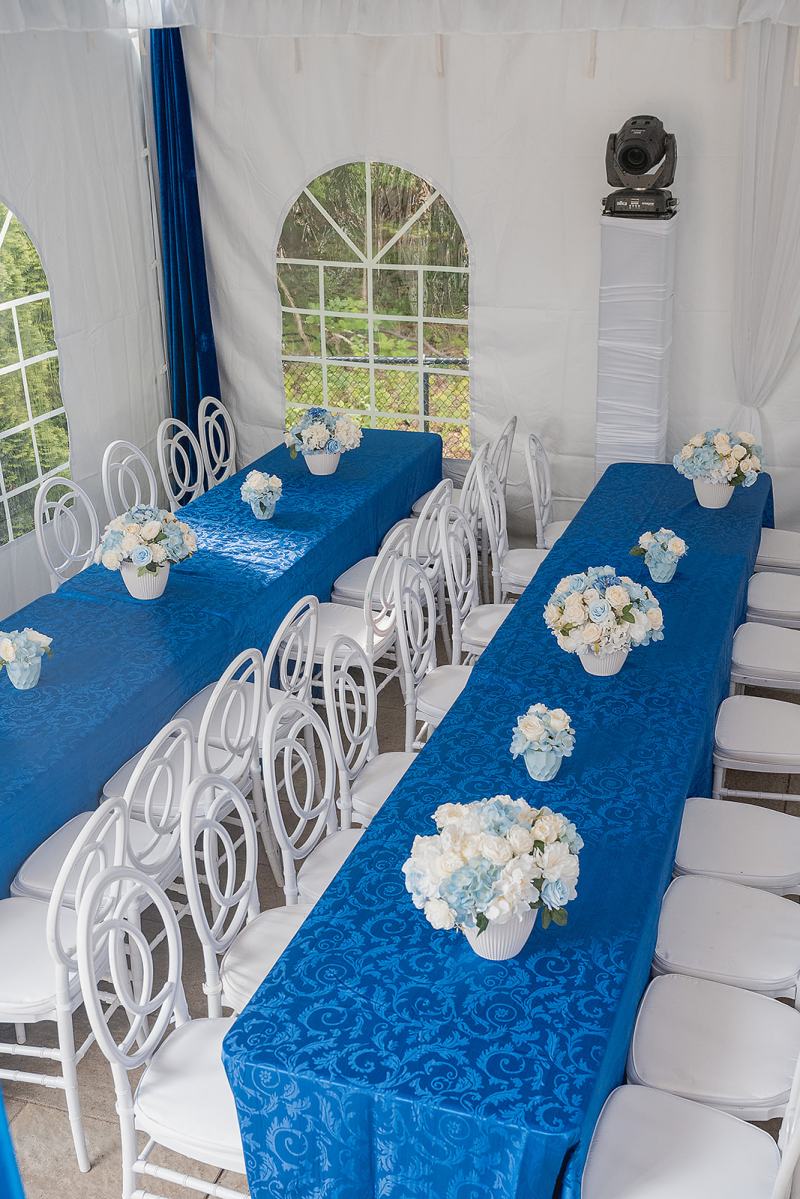 Long sangeet tables with royal blue linens and white florals by GPS Decors