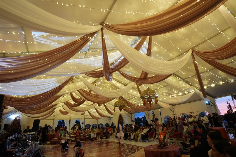 Sangeet tent with swagged ivory ceiling draping by GPS Decors