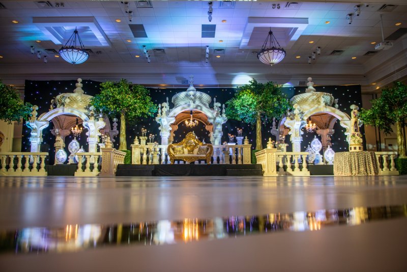 White and gold domed pavilion stage with trees, balustrades, a gold sofa and a starlight backdrop.