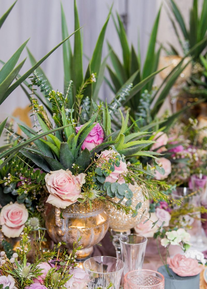 Pink roses, agave and eucalyptus in a gold mercury glass vase.