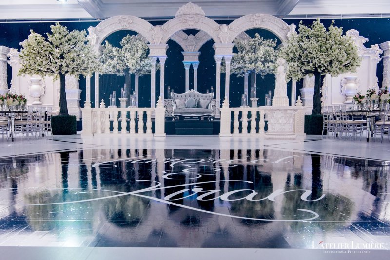 White palace arch stage with white blossom trees and a starlight backdrop above a mirrored dance floor.