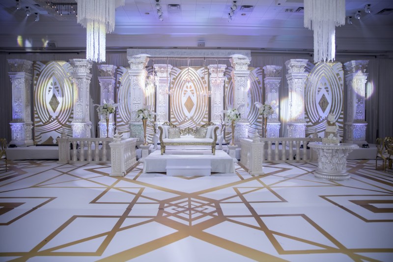 White wedding stage with a geometric gold floor design by GPS Decors